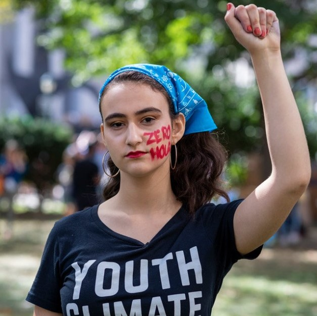 a youth with a fist raised and red ink on her face.